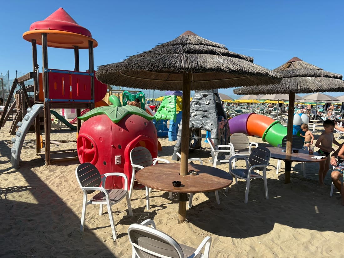 Area giochi con casetta a forma di fragola e tavoli ombreggiati al Bagno Dover 175