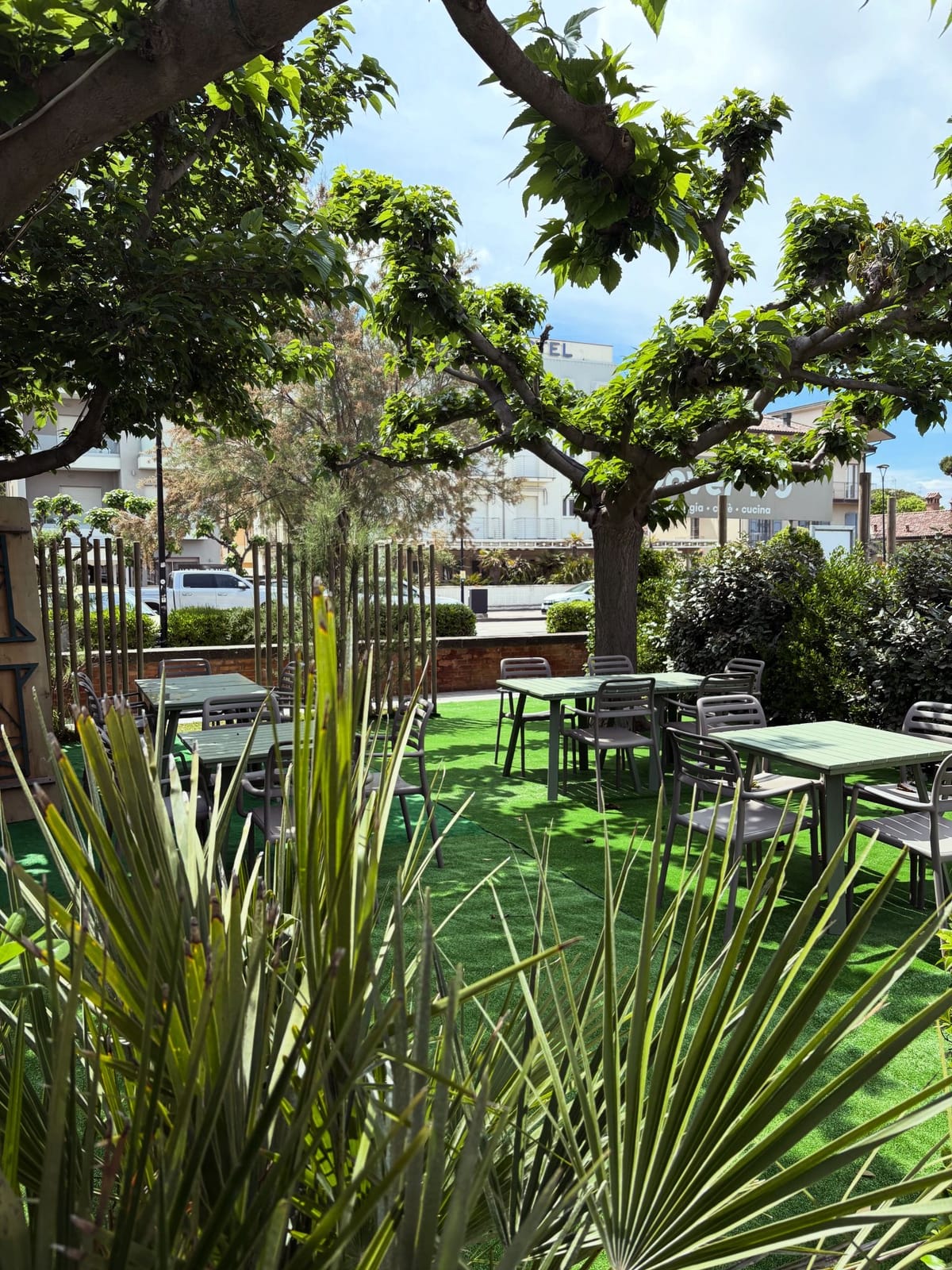 Area giardino del Bagno Dover 175 con tavoli verdi sotto gli alberi